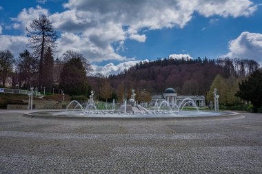 Çek Cumhuriyeti 'nin batı kesimindeki Marinsk Izn (Marienbad) spa kasabasının merkezinde şarkı söyleyen çeşme. Arka planda Karolina İlkbahar ve Spa Ormanları 'nın beyaz sütunları var..