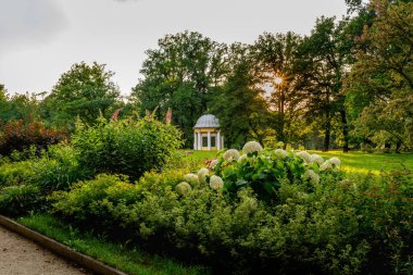 Bereketli bir bahçesi, çiçek açan çiçekleri ve büyüleyici beyaz bir çardağı var. Ağaçların arasından süzülen yumuşak güneş ışığı sakin ve romantik bir atmosfer yaratır - Frantiskovy Lazne (Franzensbad) - Çek Cumhuriyeti, Avrupa