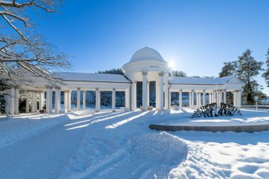 Marianske Lazne 'de (Marienbad) karla kaplı neoklasik sütunlar (Kolonada). Beyaz mimari mavi gökyüzü ile güzel bir tezat oluşturuyor. Bu ünlü kaplıca kasabasında sakin bir kış atmosferi yaratıyor..