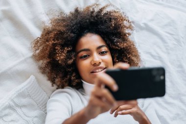 Yatakta uzanmış video blogu çeken yetenekli kadın blogcu