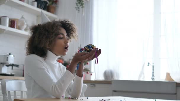 Femme africaine tient dans les mains et souffle confettis décoratifs — Video