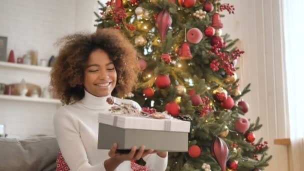 Nice lady with dark skin opens present box and smiles widely — Stock Video