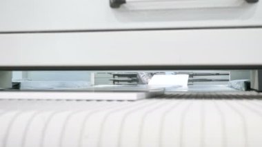 İşçi otomatik makineden boyanmış beyaz tahtaları alır