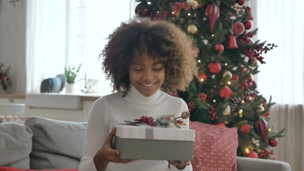 Happy woman holds present box in hands shake and smiles — Stock video