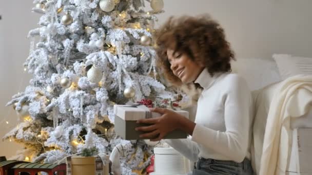 Lady houdt huidige doos tegen ontwerper witte kerstboom — Stockvideo