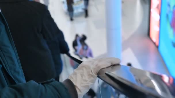 Hand im Medizinhandschuh greift nach schwarzem Handlauf der Rolltreppe — Stockvideo