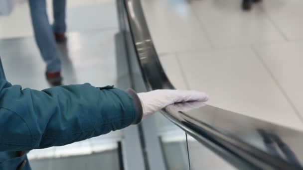Hand i medicinsk handske håller lång svart rulltrappa ledstång — Stockvideo