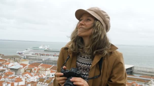 Eine junge Millennial-Touristin fotografiert die Sehenswürdigkeiten im historischen Stadtzentrum vor der Kulisse eines Kreuzfahrtschiffes und Ziegeldächern. — Stockvideo