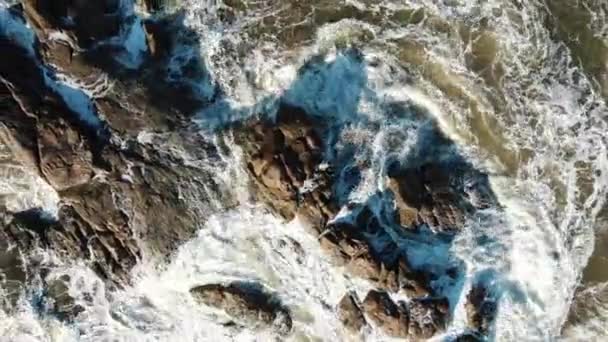 Olas del océano lavan enormes rocas haciendo espuma blanca bajo el sol — Vídeos de Stock