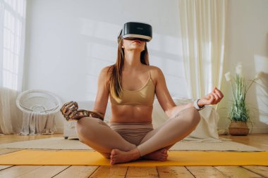 Güneşli odada biyonik protezi ve VR kulaklığı olan bir kadın.