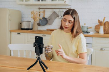 Parlak biyonik protezli kadın mutfakta video çekiyor.