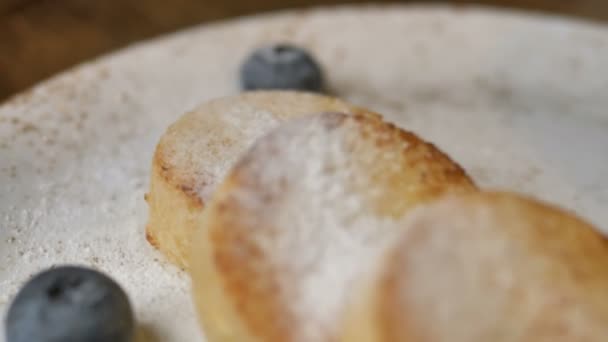 Utsökt ost pannkakor cowered med socker pulver på plattan — Stockvideo