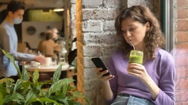 Güzel kadın yeşil sebzeleri yudumluyor taze sörf interneti