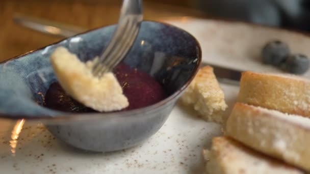 Pastel de queso empapado en tazón con mermelada de bayas en la cafetería — Vídeo de stock