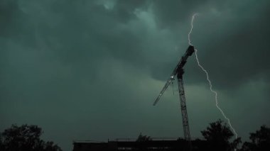 Yıldırım aynı yere birkaç kez düştü. İnşaat vinci, ağır çekim.
