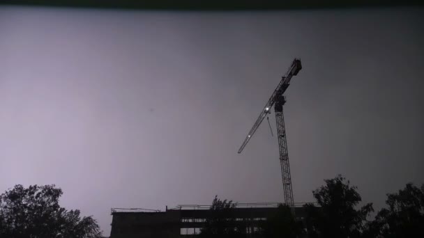 Grúa de construcción en el fondo de la nube de lluvia oscura, relámpagos, cámara lenta — Vídeos de Stock