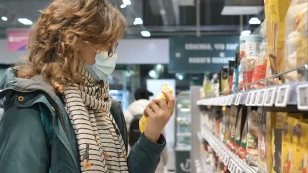 Lady sostiene el paquete en las manos y lee los ingredientes en la tienda — Vídeo de stock