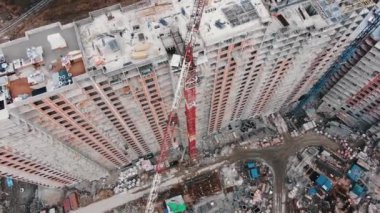 Yüksek vinç yelkeni yeni apartmanın üzerinde hareket ediyor
