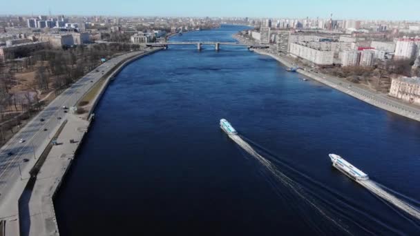 Vodní tramvaje plují podél klidné řeky protékající městem — Stock video