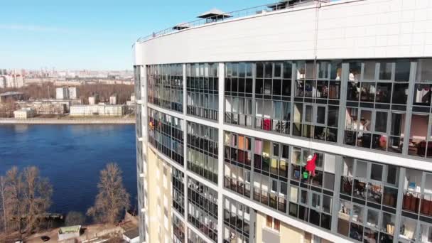 Industrial climber cleans window of hotel near river — Stock Video