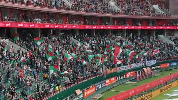 Fanoušci Lokomotiv fotbalového klubu vlny barevné vlajky na zápas — Stock video