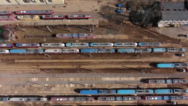 Трамваи с вагонами стоят на железных дорогах в депо — стоковое видео