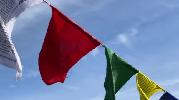 Banderas de oración budistas ondeadas por el fuerte viento cuelgan en la cuerda — Vídeo de stock