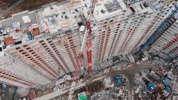Vysoký jeřáb se otáčí nad novým bytovým domem — Stock video