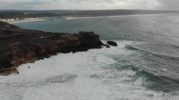 Faro en acantilado empinado cerca del océano en la antena del día lluvioso — Vídeos de Stock