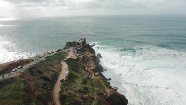 Faro en acantilado empinado cerca del océano en la antena del día lluvioso — Vídeos de Stock