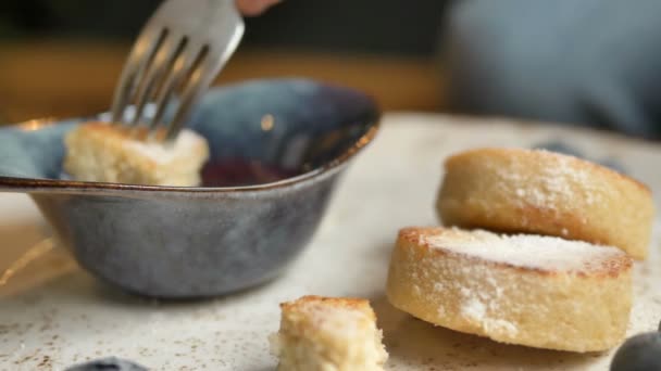 Pastel de queso empapado en tazón con mermelada de bayas en la cafetería — Vídeos de Stock