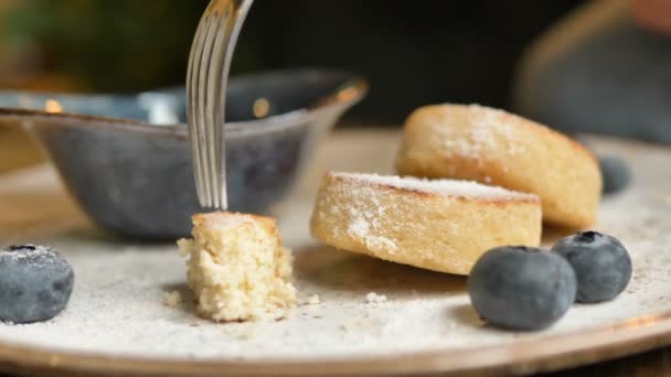 Tenedor de metal y cuchillo de corte pieza de panqueque de queso en la cafetería — Vídeos de Stock