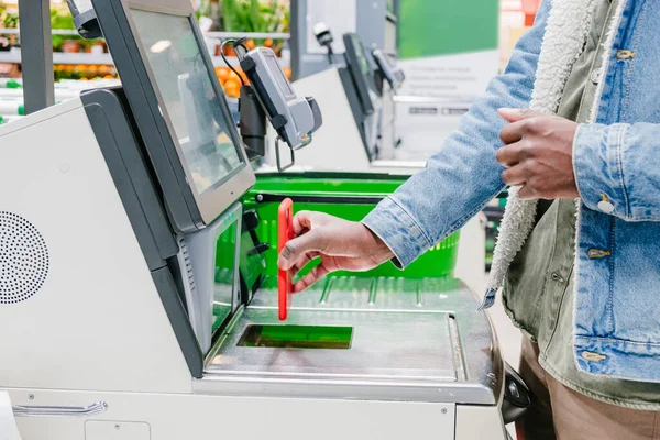 Black guy uses smartphone to pay at self-checkout point — Zdjęcie stockowe