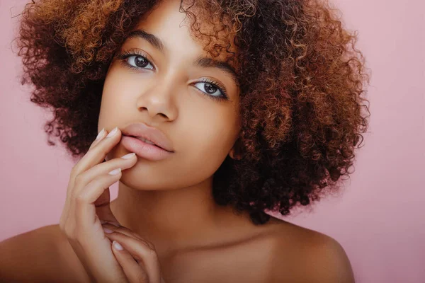Krásný portrét krásné afroamerické mladé ženy s tajemným pohledem na kameru a její prsty na tváři — Stock fotografie