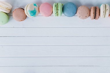 Beyaz ahşap zemin üzerinde makarna ya da makarna, beyaz masa üzerinde badem kurabiyeleri, boşluğu kopyala