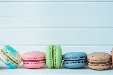Beyaz ahşap arka planda bir sıra badem kurabiyesi, masada badem kurabiyesi, boşluğu kopyala.