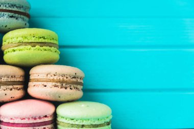 Turkuaz ahşap zemin üzerinde çok renkli simit piramidi, kapat ve uzayı kopyala