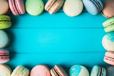 Turkuaz ahşap zemin üzerinde çok renkli badem kurabiyesi, dekorasyon şeklinde badem kurabiyesi, kopyalama alanı.