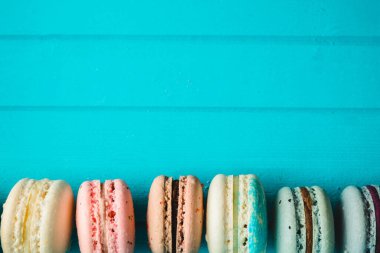 Turkuaz ahşap arka planda taze kurabiye, çok renkli bademli kurabiyeler. Boşluğu kopyala