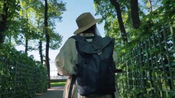 Junge Künstlerin mit braunem Strohhut und schwarzem Rucksack — Stockvideo