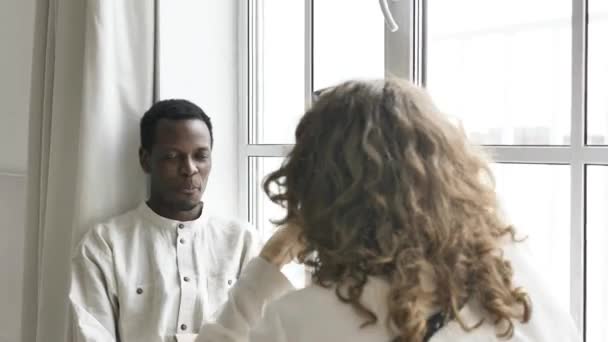 Mulher tira foto de homem afro-americano perto da janela — Vídeo de Stock