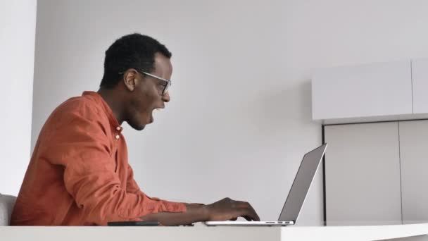 L'uomo afro-americano si sorprende lavorando sul computer portatile — Video Stock