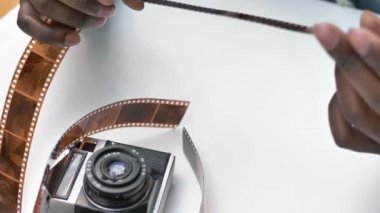 Gülümseyen Afrikalı Amerikalı adam fotoğraflı filme bakıyor.