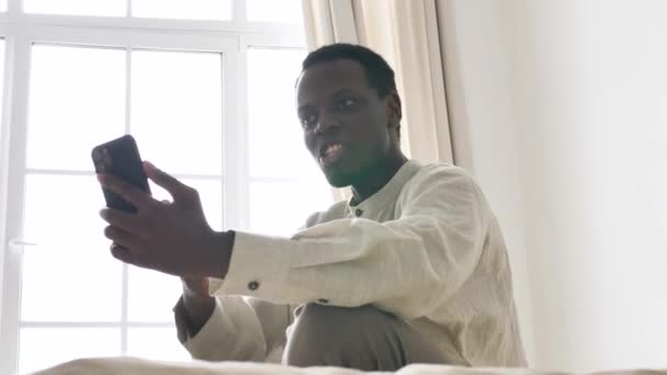 Αφροαμερικάνος μιλάει στο τηλέφωνο στο βίντεο στο δωμάτιο. — Αρχείο Βίντεο