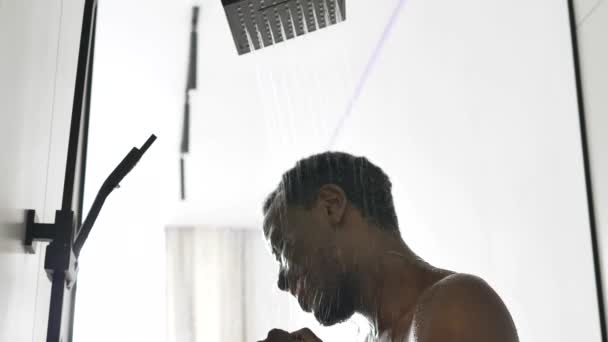 Positiver Afroamerikaner tanzt unter heißer Dusche — Stockvideo