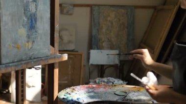 Sanatçı, stüdyodaki soyut resim tuvaline resim uygular