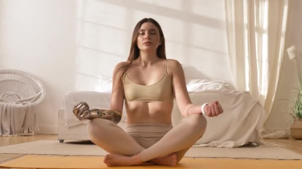 Γυναίκα με βιονικό χέρι κάνει αναπνοή γυμναστική κοντά στο κρεβάτι — Αρχείο Βίντεο