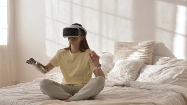 Dame mit bionischem Arm und Virtual-Reality-Headset spielt Spiel — Stockvideo