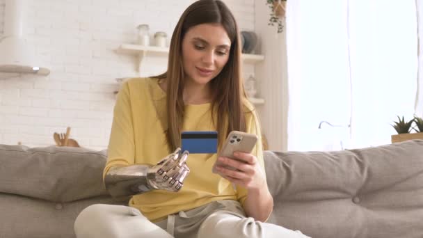 Mulher feliz com braço biônico usa cartão de crédito para pagar online — Vídeo de Stock