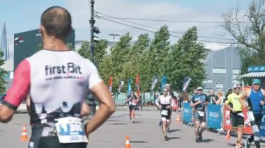 Cesur sporcular ağır çekimde Ironman Triatlonu 'nda maraton koşuyor.